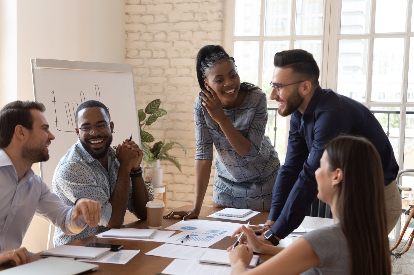 Colleagues sharing ideas around a table in a bright office
